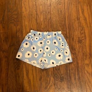 A pair of blue shorts with flowers and a belt size extra small